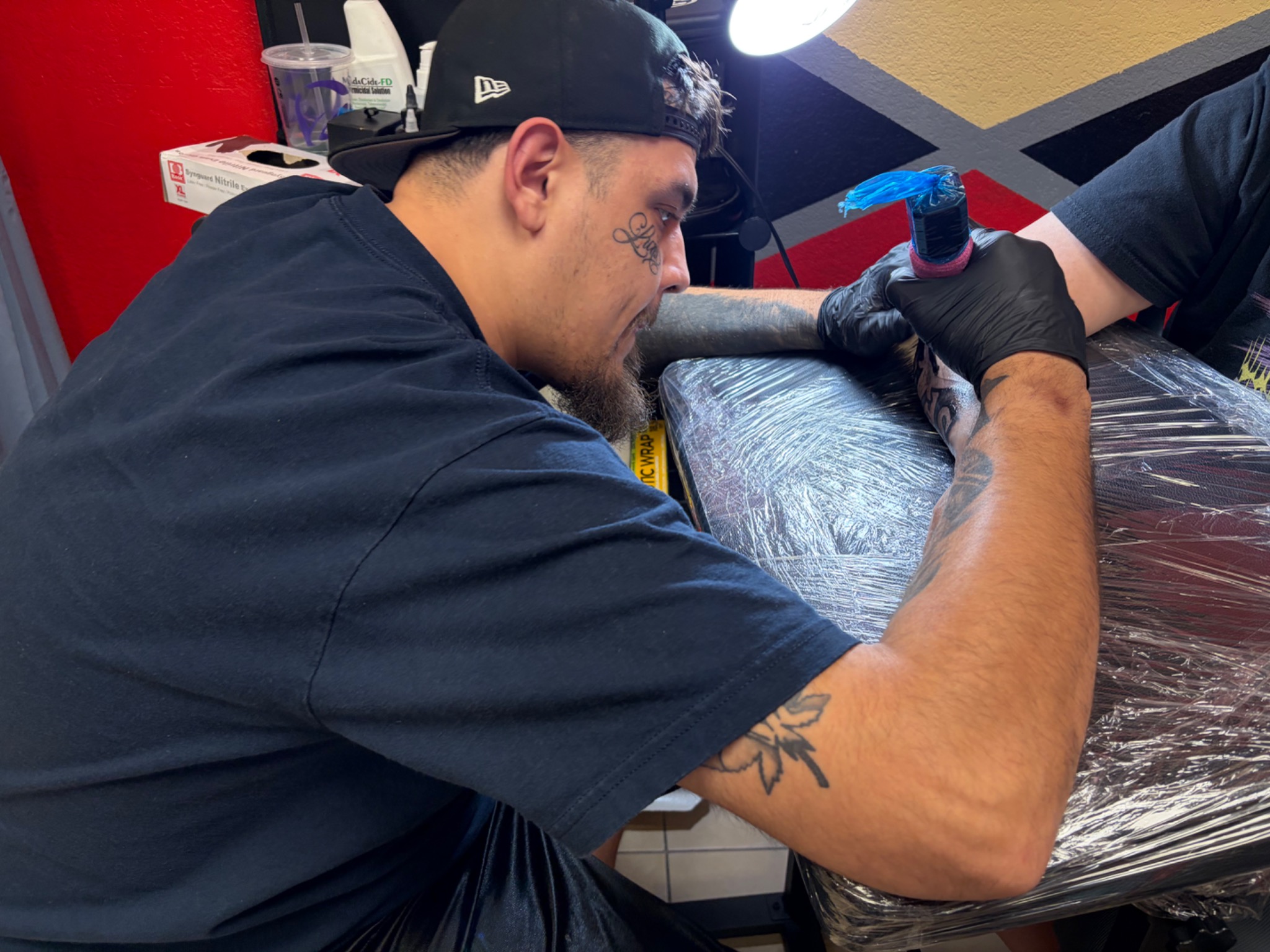 DEEZUS INK tattoo artist working on a client