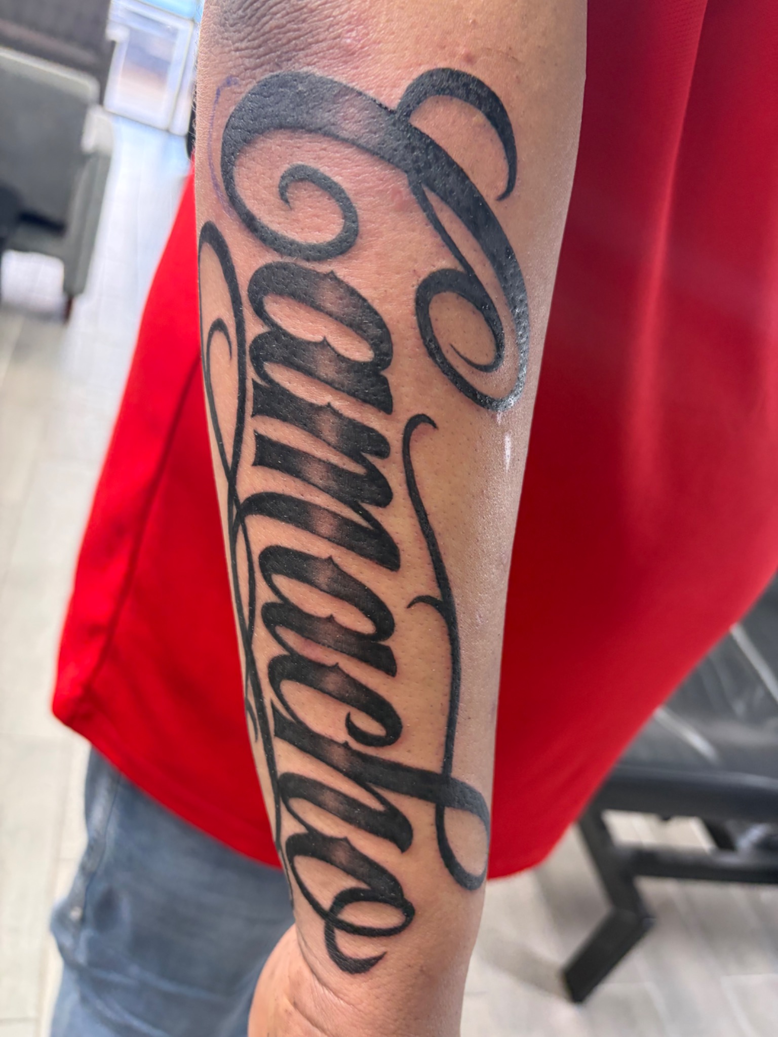 Large black custom script forearm tattoo