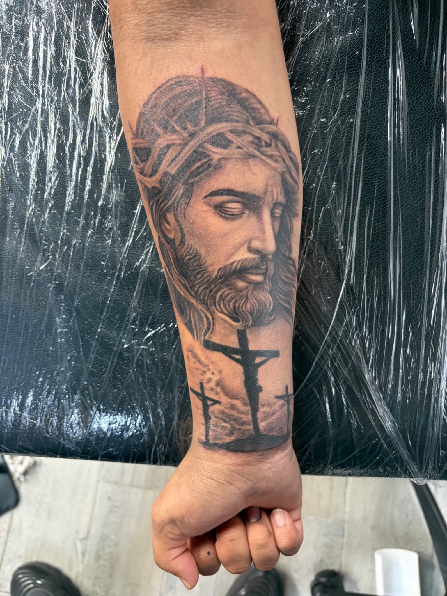 Black and grey Jesus portrait and crosses tattoo
